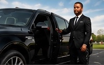 Chauffeur standing beside a luxury vehicle